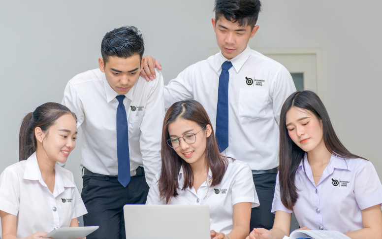 Employees wearing white company logo shirts are in the office